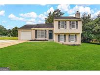 Two-story house with attached garage and manicured lawn at 4982 Millstone Walk, Stone Mountain, GA 30088