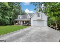 White house with a two-car garage and a spacious yard at 4378 Ridge Ct, Loganville, GA 30052