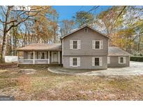 Two-story house with gray siding, a porch, and a driveway at 849 Wagon Wheel Cir, Fayetteville, GA 30214