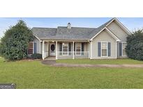 One-story house with gray siding, a covered porch, and a landscaped lawn at 231 Ferguson Ave, Locust Grove, GA 30248
