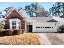 Brick ranch home with white garage door and landscaping at 116 Willow Creek Dr, Peachtree City, GA 30269