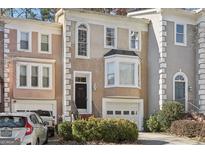 Charming townhome featuring classic architectural details and a well-maintained front yard with a one-car garage at 3863 Meeting St, Duluth, GA 30096