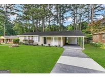 Ranch style home with carport, mature trees, and well-manicured lawn at 3568 Glenview Cir, Atlanta, GA 30331