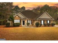 Brick ranch home with a landscaped yard and a driveway at 409 Bellway Ct, Tyrone, GA 30290