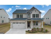 Two-story brick home with a large front yard and attached two-car garage at 1705 Goodwin Dr, Hampton, GA 30228