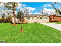 Ranch home with a well-manicured lawn and new concrete driveway at 3438 Maryvale Dr, Decatur, GA 30032