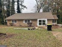 Ranch style home with a tan exterior, multiple windows and a large yard at 45 North Ave, Hampton, GA 30228