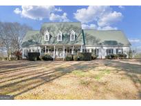 Two-story house with green roof, white siding, and large front porch at 2800 S Highway 16, Carrollton, GA 30116