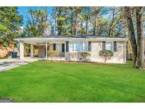 Charming ranch home with a spacious lawn and covered carport at 2442 Graywall St, East Point, GA 30344