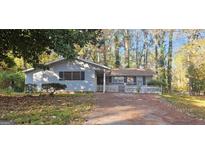 Ranch style home with brick and siding exterior, white picket fence, and driveway at 3603 Manhattan Dr, Decatur, GA 30034