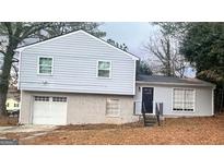 Two-story house with gray siding, attached garage, and a landscaped yard at 8816 Ashwood Dr, Riverdale, GA 30274