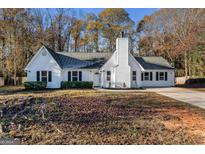 Charming two-story home with white siding, a prominent chimney, and a driveway at 215 Woodfield Ct, Mcdonough, GA 30253