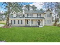 Charming two-story home with a lush green lawn and covered front porch at 1091 Cherry Laurel Dr, Lithonia, GA 30058