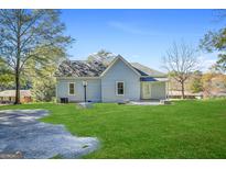 Back view of a charming light blue two-story home with a grassy backyard at 214 Williamson Mill Rd, Jonesboro, GA 30349