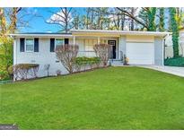 Charming single-story home with a white brick exterior, attached garage, and lush green lawn at 2830 Battle Forrest Dr, Decatur, GA 30034