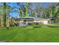 Charming ranch-style home with a lush green lawn and mature trees at 2003 Rosewood Rd, Decatur, GA 30032