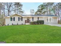 Front exterior of a single-story home with a manicured lawn and updated facade at 464 Stonewood Dr, Stone Mountain, GA 30087