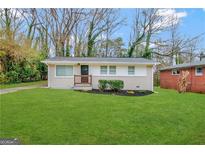 Renovated single-story home with a small front porch, lush green lawn, and mature trees at 3429 Adkins Nw Rd, Atlanta, GA 30331