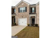 Attractive townhome exterior with a one-car garage and brick facade at 1304 Speckle Park Way, Stockbridge, GA 30281