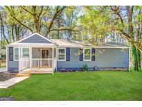 Charming blue single-story home with a covered front porch and landscaped yard at 2556 Godfrey Nw Dr, Atlanta, GA 30318