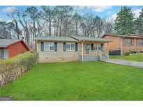Charming single-Gathering home with lush green lawn and covered porch at 261 Howell Sw Ter, Atlanta, GA 30331