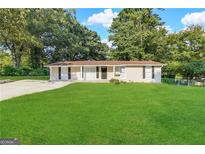 Single-story home with a large front lawn and trees at 6069 Wisteria Ln, Lithia Springs, GA 30122