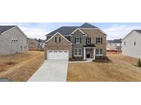 New construction home with a stone and brick exterior, and a two-car garage at 671 Edgar St, Hampton, GA 30228