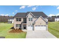 Beautiful two-story home with a three-car garage and landscaped yard at 667 Edgar # 26, Hampton, GA 30228