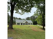 Ranch style home with metal roof and landscaped yard at 52 Shadow Ct, Palmetto, GA 30268