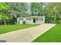 Ranch style home with a paved driveway and grassy yard at 10214 Allen Sw Dr, Covington, GA 30014