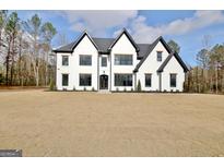 Two-story modern farmhouse with white siding, black accents, and a spacious lawn at 115 Grace Hope Dr, Brooks, GA 30205