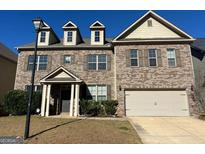 Charming brick two-story home featuring a covered entrance and two-car garage at 566 Mariposa Ln, Mcdonough, GA 30253