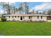 Ranch style home with brick facade, and a well-manicured lawn at 1908 Delowe Sw Pl, Atlanta, GA 30311