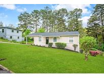 Charming Ranch home with a well-manicured lawn and mature trees at 3809 Clovis Nw Ct, Atlanta, GA 30331