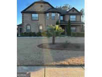 Two-story brick home with a large front yard and attached garage at 2801 Karras Cv, Hampton, GA 30228