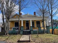 Charming yellow house with a spacious front porch and mature trees at 1786 Lakewood Se Ave, Atlanta, GA 30315