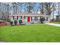 Ranch style home with gray exterior, red door, and green lawn at 2252 Brannen Se Rd, Atlanta, GA 30316