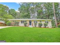 Ranch style home with a spacious lawn and mature trees at 3029 Mckenzie Rd, East Point, GA 30344