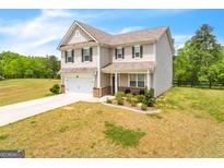Two-story house with attached garage, landscaping, and a spacious yard at 4929 Calgary Dr, Douglasville, GA 30135