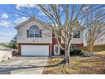 Two-story house with a brick and siding exterior, attached garage, and landscaping at 4626 Derby Loop, Fairburn, GA 30213