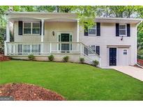 Brick ranch house with a green door, white railings, and a well-manicured lawn at 4436 Malibu Dr, Decatur, GA 30035
