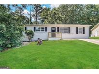 Updated Ranch home features a fresh coat of paint and a well-manicured lawn at 10178 Allen Sw Dr, Covington, GA 30014