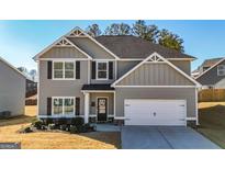 Two-story house with gray siding, white garage door, and landscaping at 1145 Red Bud Cir, Villa Rica, GA 30180