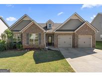 Brick house with a two-car garage and a well-manicured lawn at 1611 Stillriver Run Dr, Mcdonough, GA 30252