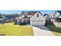 Two-story house with white siding, large windows, and a spacious front yard at 112 Twelve Parks Trail, Sharpsburg, GA 30277