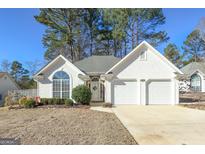 White house with two-car garage and landscaped yard at 302 Preston Chase Dr, Peachtree City, GA 30269