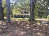 Gray house with light blue door, a long driveway, and large trees in the front yard at 361 Almon Rd, Covington, GA 30014