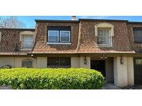 Charming two-story townhome with a brown shingled roof and manicured shrubs at 3000 Parc Lorraine, Lithonia, GA 30038