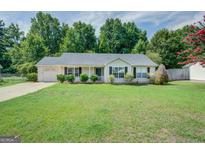 Ranch-style home with a carport and well-maintained lawn at 6273 Amberly Rd, Rex, GA 30273