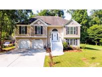 Two-story house with a two-car garage and a welcoming front porch at 6277 N Sweetwater Rd, Lithia Springs, GA 30122